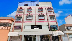A hotel building with multiple balconies, a sign reading 'HOTEL & Company Service,' and a clear blue sky in the background. - Deluxe Rupashi Restaurant And Guest House (Shrirampur)