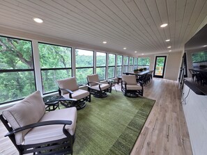 Una habitación amplia con ventanas grandes, una mesa larga y varias sillas.