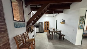 A spacious kitchen with wooden furniture, a staircase, and a refrigerator. - Rustic and cozy beach house with 4 ensuites (Vila Velha)