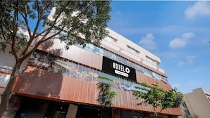 A hotel with a prominent sign, multiple floors, and a modern facade. - Deluxe Hotel O Sunkadakatte (Bengaluru)