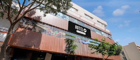 A hotel with a prominent sign, multiple floors, and a modern facade.