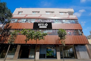 A hotel with a prominent sign, multiple floors, and a modern architectural design. - Deluxe Hotel O Sunkadakatte (Bengaluru)