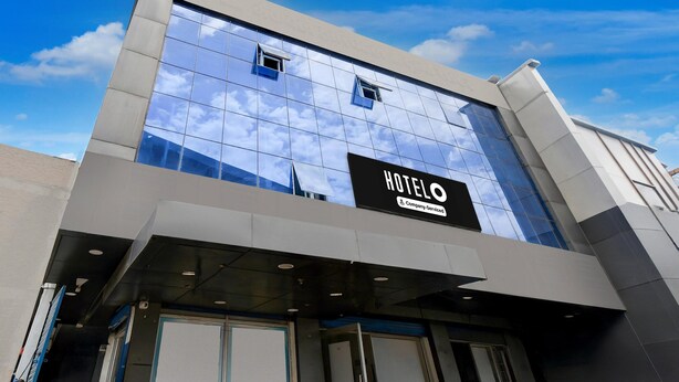 A modern hotel building with a glass facade reflecting the sky, a prominent 'HOTEL' sign, and a clean, contemporary design. - Deluxehotel Mayur Residency (Gorakhpur)