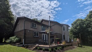 Une cabane en rondins à deux étages, dotée d’une terrasse et d’un espace salon extérieur.