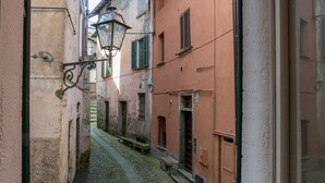 Una estrecha calle empedrada bordeada por edificios de arquitectura tradicional, incluyendo un farol y un estrecho pasaje.