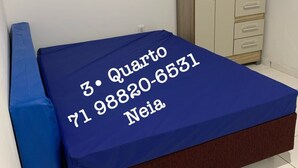 Un dormitorio con cama, armario y cubrecolchón azul.