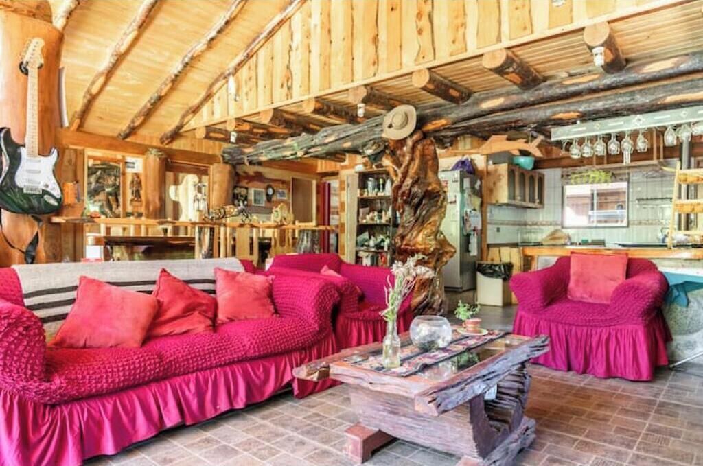 Un intérieur rustique en bois, avec un canapé, une table basse et une guitare.