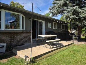 Une propriété résidentielle dotée d’une terrasse, d’un espace barbecue et d’une grande fenêtre.