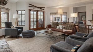 Un salón amplio con sofá, sillones, una mesa de centro y chimenea.