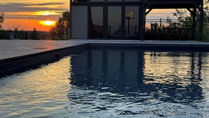 Una piscina con el atardecer de fondo.