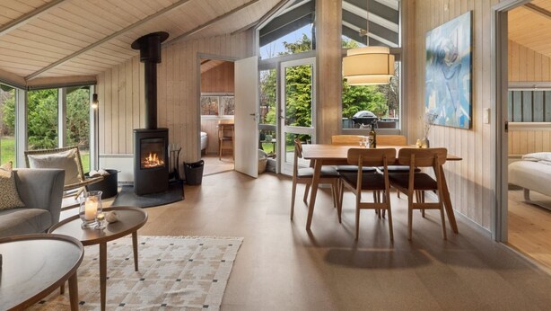 Een knus interieur met een open haard, houten meubels en grote ramen.