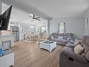 A spacious living area with a sofa, a coffee table, and a television. - Emerald Escape Up - Duplex in Emerald Isle - 3BR (Emerald Isle)