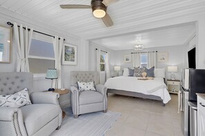 A bedroom with a large bed, two armchairs, a ceiling fan, and a TV. - 2.5-Acre Compound: 8BR/6BA w/ Pool & Pickleball (Naples)