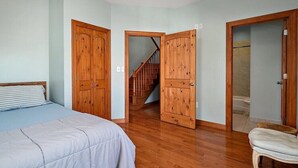 Ein Schlafzimmer mit Bett, Holzschrank und Stuhl.