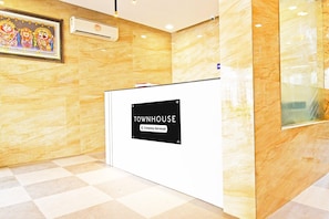A reception desk with a sign reading 'TOWNHOUSE Company Serviced.'
