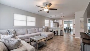 A modern living room with a sectional sofa, a coffee table, and a ceiling fan. - Beautiful Tampa Pool/Hot Tub Home-Spacious Yard (Tampa)