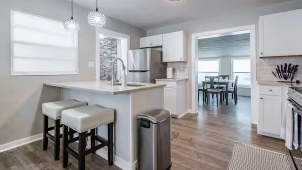 A modern kitchen with a bar area, stainless steel appliances, and pendant lighting. - Beautiful Tampa Pool/Hot Tub Home-Spacious Yard (Tampa)