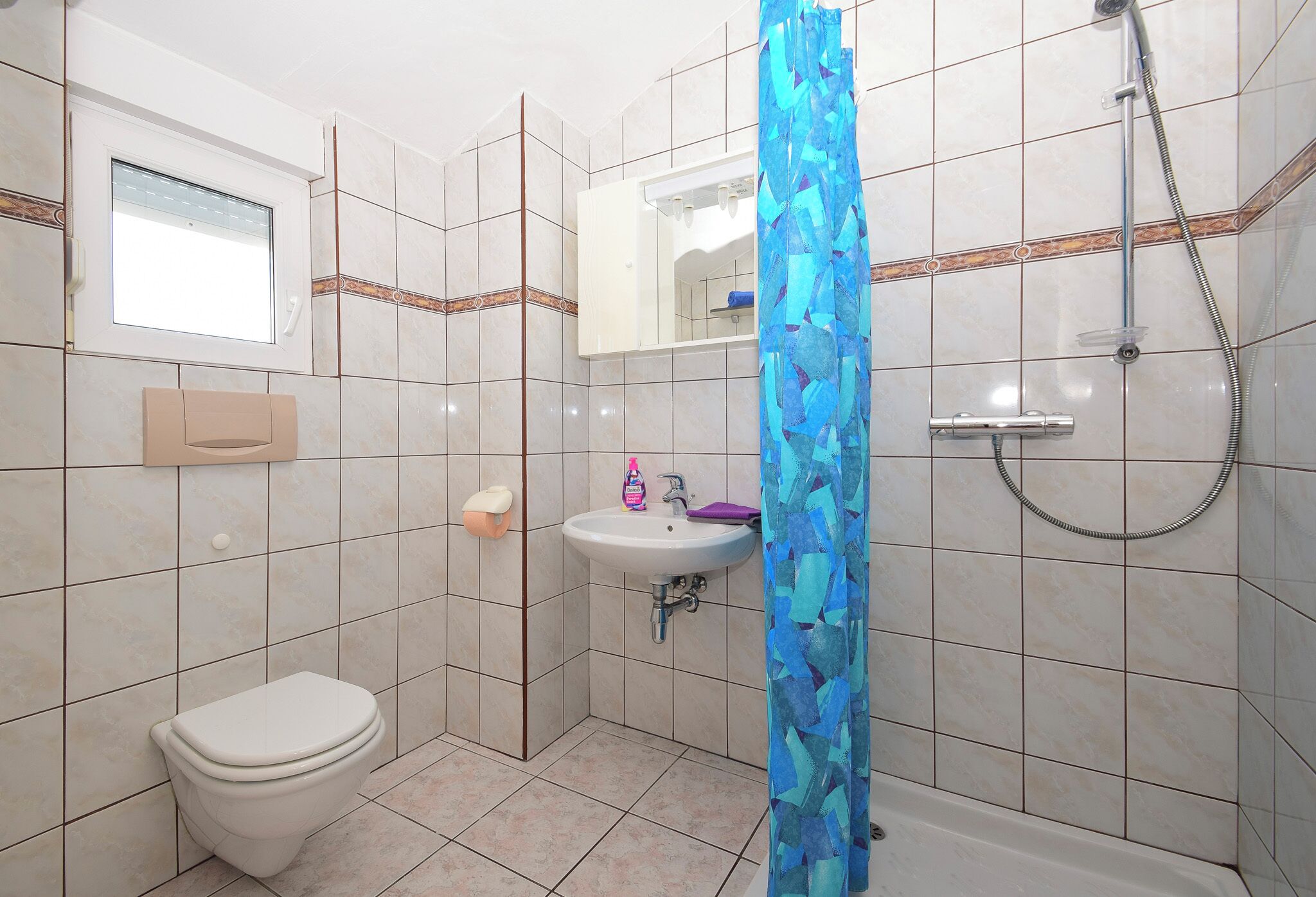 Een douche, handdoeken, toiletpapier