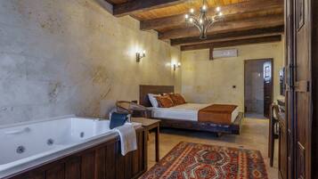Un baño rústico con una bañera, un banco de madera y una cama con un tapete estampado.