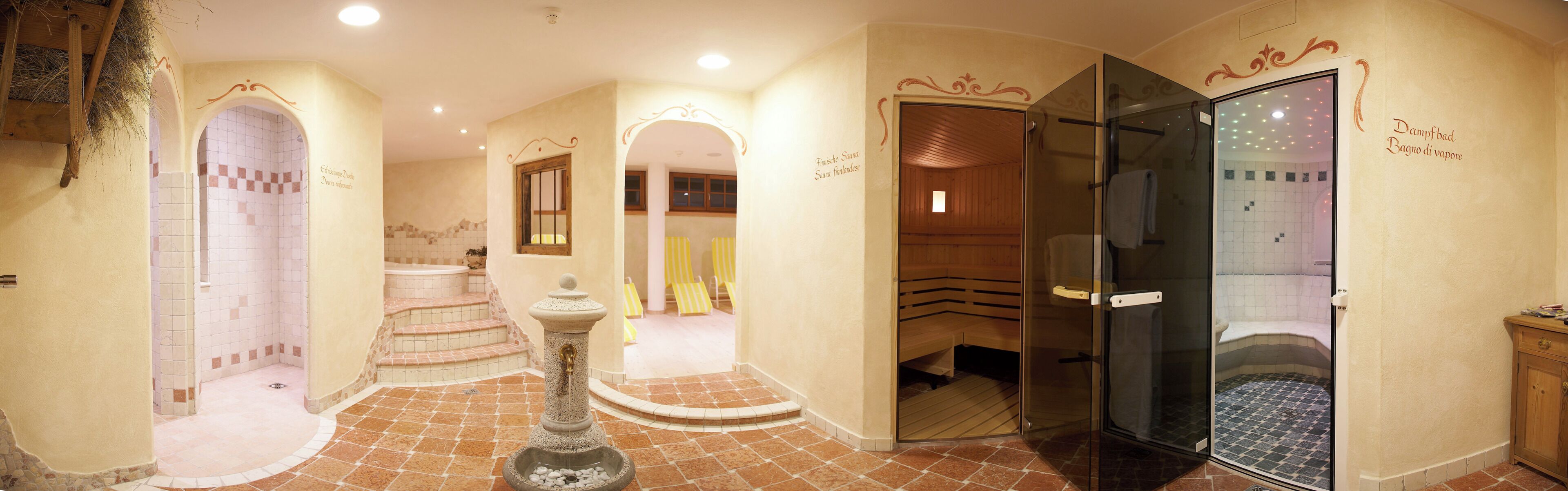A spa area with a sauna, a glass-enclosed shower, and a stone fountain.