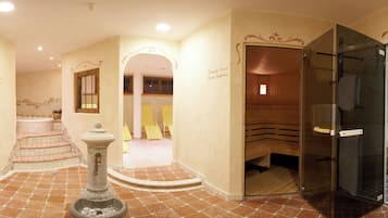 A spa area with a sauna, a glass-enclosed shower, and a stone fountain.