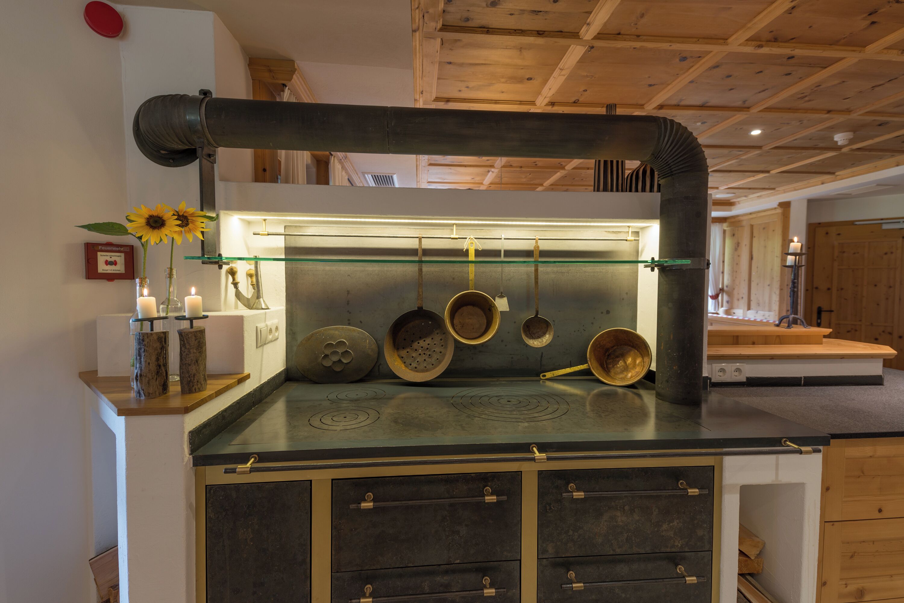 Eine Küche mit Kochinsel, Holzschränken und einer Vitrine mit Glastüren.