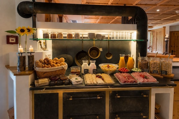 Un bufé con diversas opciones de comida, incluyendo carnes, quesos y salsas.