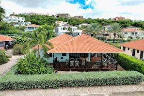 A residential area with houses, a covered outdoor seating area, and well-maintained gardens.
