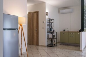 Une cuisine compacte équipée d’un réfrigérateur, d’un four à micro-ondes et d’une étagère.