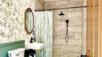 Ein Badezimmer mit Toilette, Waschbecken, Dusche und Spiegel.