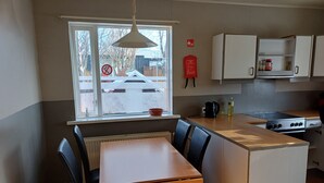 Eine kleine Küche mit Essbereich, einem Fenster und Aussicht sowie einem an der Wand befestigten Feuerlöscher.