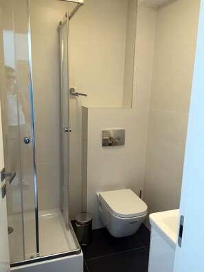 Een douche, een haardroger, zeep, toiletpapier