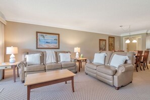 A living room with two sofas, a coffee table, and a dining area with chairs and a table. - Quiet Comfortable 2br-2ba Condo in Saddlebrook (Zephyrhills)