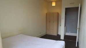 A bedroom with a bed, a wardrobe, and a door leading to another room. - A good flat close to university! (Manchester)