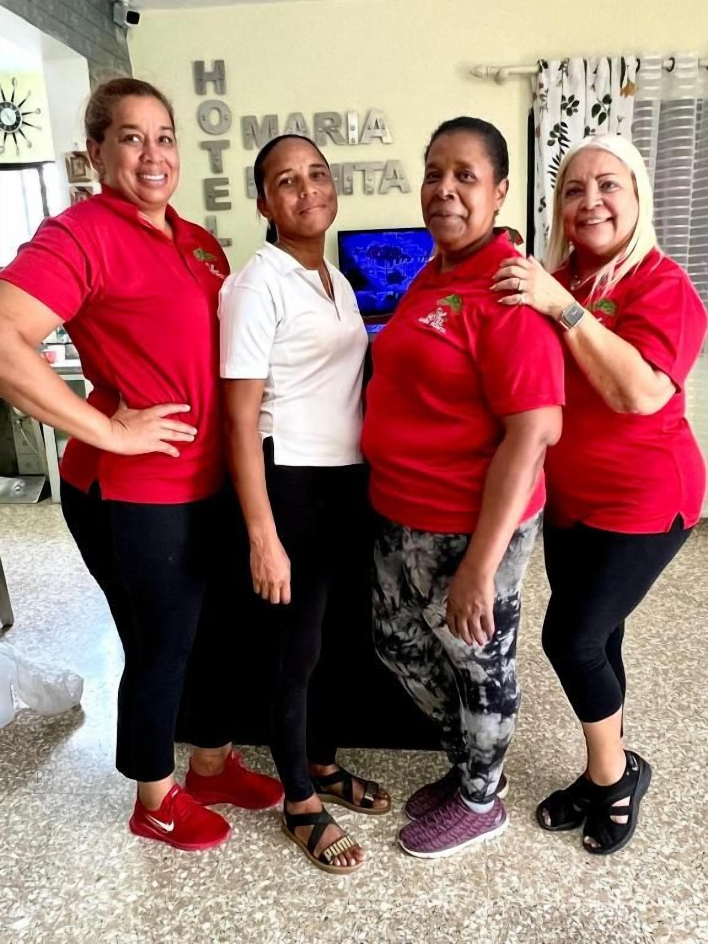 A group of people standing in a lobby with a sign that reads 'Maria Hotel.'