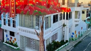 Rakennuksessa on kyltti, jossa lukee ”HOTEL MARIA BONITA HIGUÉY”, ja sen edessä kasvaa puu.