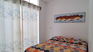 Una camera da letto con un letto, una finestra con tende, un quadro appeso al muro e una lampada a soffitto.