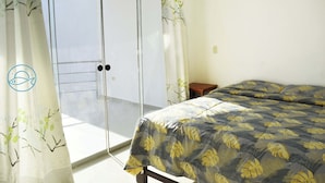 Una stanza con un letto, un tavolino, una porta scorrevole e vista sull'esterno.