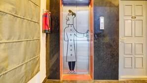 An elevator with a cartoon character, a fire extinguisher, and a door with the number 401. - Deluxetownhouse Sarjapur Near Bellandur (Bengaluru)