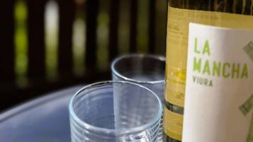 Une bouteille de vin de La Manche, avec son étiquette, est posée sur une table à côté de deux verres vides.