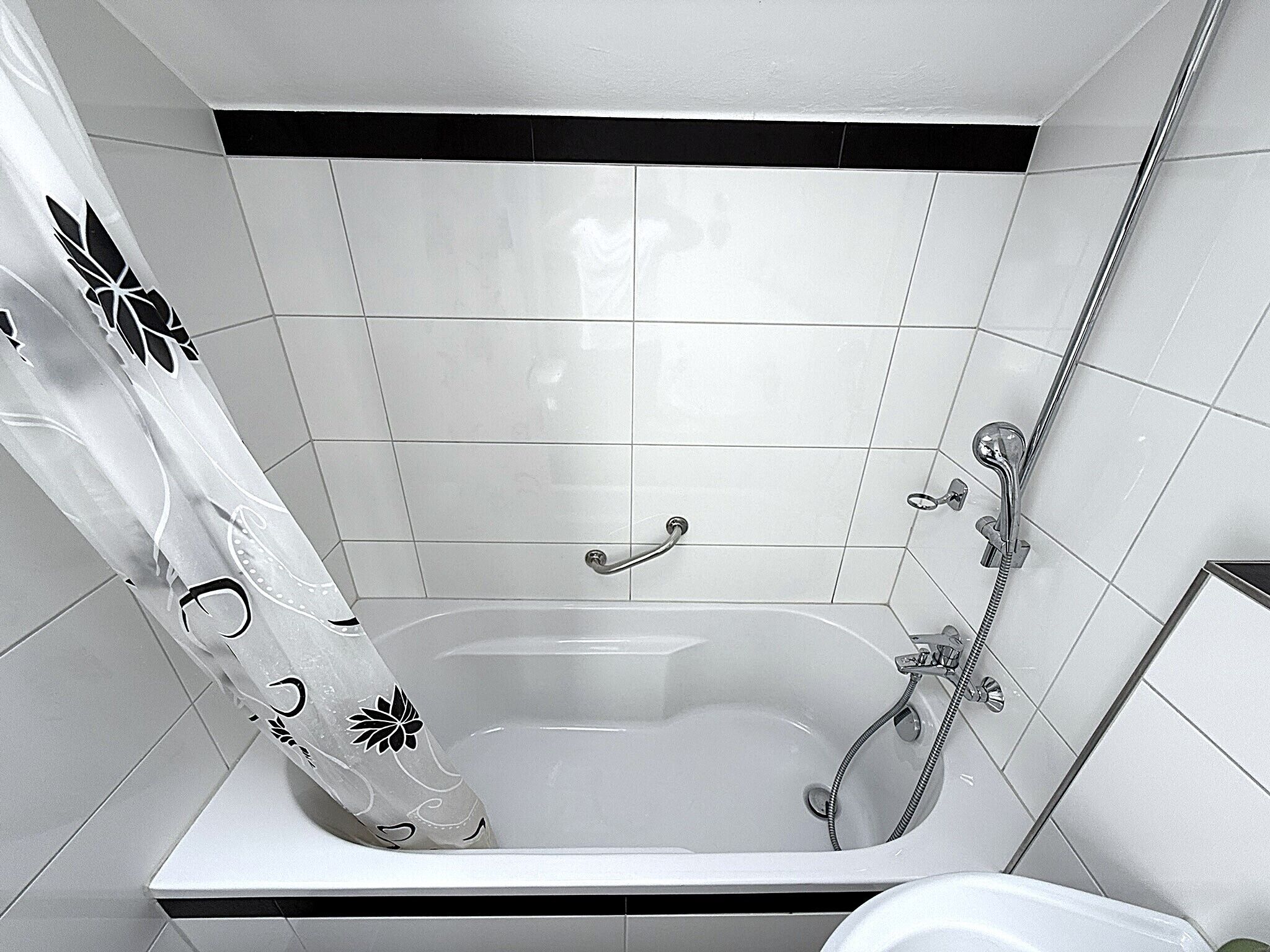 A bathroom with a bathtub, shower, and toilet.