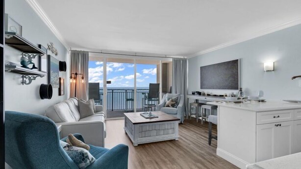 Ein modernes Wohnzimmer mit Sofa, Couchtisch und einem Balkon mit Blick.