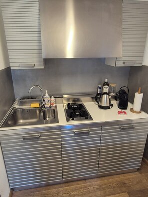 Placa de cocina, cafetera o tetera, tostadora y utensilios de cocina