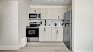 Une cuisine moderne équipée d’un four à micro-ondes, d’une cuisinière, d’un four et d’un réfrigérateur.