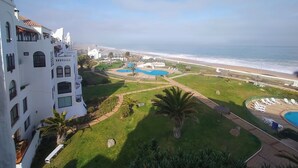 Een resort met een zwembad, een strand en uitzicht op de oceaan.
