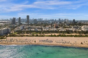 Eine Küstenstadt mit breitem Strand, hoch aufragenden Gebäuden und blauem Himmel.
