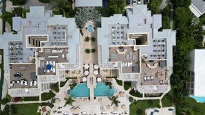 Ένα θέρετρο με μια κεντρική πισίνα, πολλούς χώρους εστίασης και καθιστικά σε εξωτερικό χώρο.