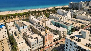 A coastal cityscape with a beach, buildings, and palm trees. - Chic 1BR in the Heart of SoBe Ocean 1 Min Away 308 (Miami Beach)
