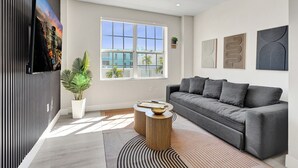A modern living room with a sofa, coffee table, and artwork on the walls. - Comfortable 1BR Apartment in Prime South Beach 307 (Miami Beach)