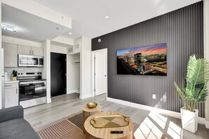 A modern living room with a flat-screen TV, a sofa, and a coffee table. - Cozy 1BR in the Heart of SoBe Ocean 1 Min Away 305 (Miami Beach)